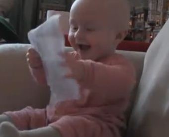 Το μωρό που απολαμβάνει το σκίσιμο χαρτιού